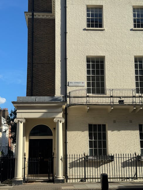 A white brick wall with a street sign reading 'BRUNSWICK MEWS W1' attached to the upper right side, situated in an outdoor urban setting under natural light. The wall appears clean and well-maintained