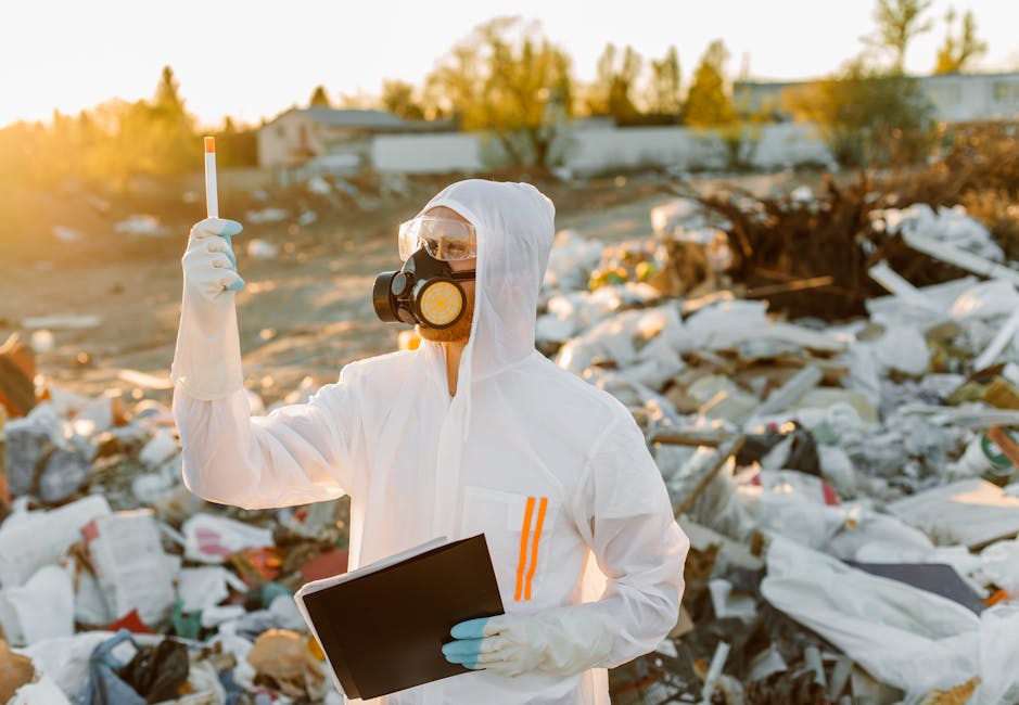 A large pile of black trash bags filled with waste is positioned next to a modern building wall with beige tile panels, some graffiti with the word 'XEND' spray-painted in red, and partially visible u